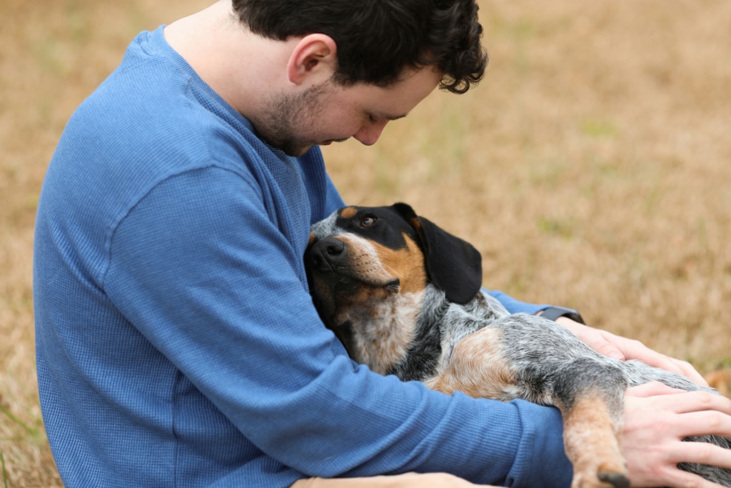 Dog in ownerโs arms after dental problems were detected, supported by Oven-Baked Tradition for dental care for dogs
