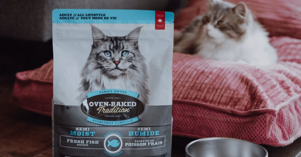 Cat with a bag of Oven-Baked Tradition fish-based semi-moist cat food, an innovative recipe for cats.